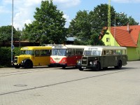 Drei historische Busse stehen auf dem Betriebhof nebeneinander.